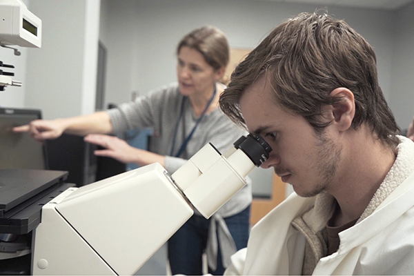 student using microscope