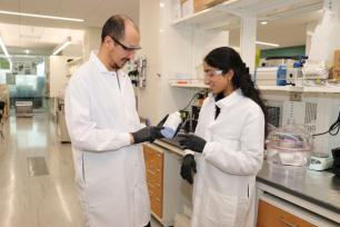 2024 My Green Lab Consultants Zaman Ataie and Ananya Gollakota check the expiration date on a chemical bottle.