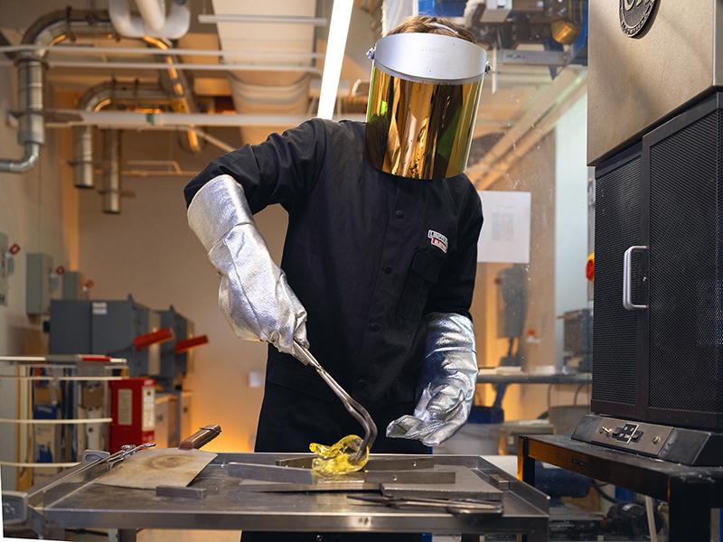 Nicholas Clark molds a piece of glass after removing it from a forge in the team's research lab